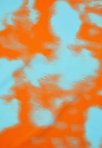 Tissu abstrait avec un motif ondulé en orange et bleu clair. Texture lisse avec un mélange de couleurs créant une apparence fluide.