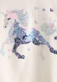 Hvidt stof med et enhjørningdesign lavet af multifarvede pailletter i nuancer af lilla, blå og pink, med spredte dekorative pailletter.