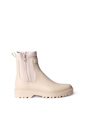 Beige ankelregnstøvle med sidelukning, trækflig bagpå og tekstureret sål for godt greb, vist mod en hvid baggrund.