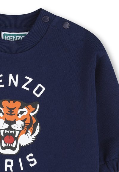 Felpa blu mare con bottoni automatici sulla spalla, con grafica di una tigre ruggente e la scritta "KENZO PARIS" sul davanti.