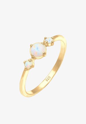 Zeltīta gredzena ar trim opālu akmeņiem, diviem maziem un vienu lielāku, kas iestiprināti apaļās kniedēs. Marķēts ar "925" zīmi, kas norāda, ka tas ir sudrabs.