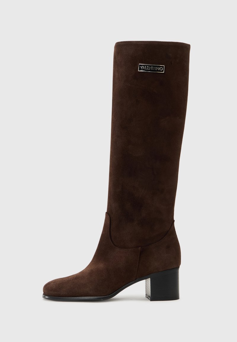Stivale marrone in suede fino al ginocchio con silhouette dritta, tacco a blocco e accentuazione del logo vicino alla parte superiore. Texture liscia con punta rotonda.