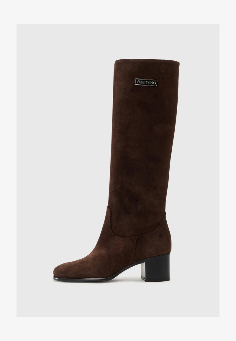 Brown suede knee-high boot features a straight silhouette, block heel, and logo accent near the top. Smooth texture with a rounded toe.