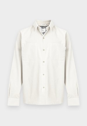 Puuvillane sametpluus helevalges toonis, pikad varrukad, nööpidega eesmine osa, kaks rinnataskut ja lõdvestunud istuvus peene soonikuga.