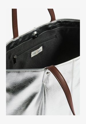 Srebrna torba na ramię z brązowymi skórzanymi uchwytami, ukazująca wnętrze podszewki oraz małą zasuwaną kieszonkę z metką "Love & Roses".