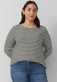 Langarmtop met zwart-witte horizontale strepen, ronde halslijn, ontspannen pasvorm en zachte stof, gecombineerd met blauwe denim jeans.