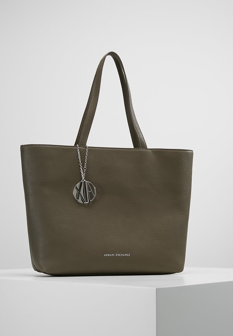 Sac cabas en cuir vert olive foncé avec double poignée, logo Armani Exchange et breloque ronde en argent suspendue à une poignée.