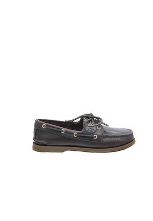 Scarpa da barca in pelle marrone scuro con cuciture moc toe, allacciatura frontale e suola in gomma, vista laterale su sfondo bianco.