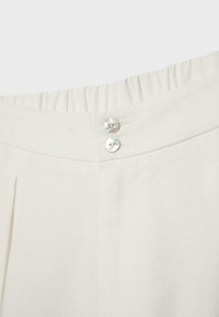 Ceinture de pantalon blanc cassé avec dos élastique et deux petits boutons nacrés au centre avant.