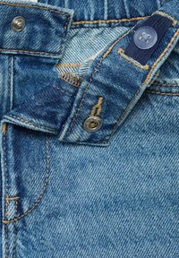 Jeans din denim de culoare bleu deschis, cu cusături contrastante, închidere cu nasture din metal și un design clasic cu cinci buzunare.