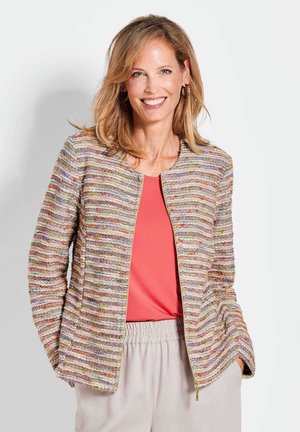 Textuur, multikleurige jas met een ritssluiting aan de voorkant en een ronde halslijn, gecombineerd met een koraalkleurig topje en lichte, elastische broeken met tailleband.