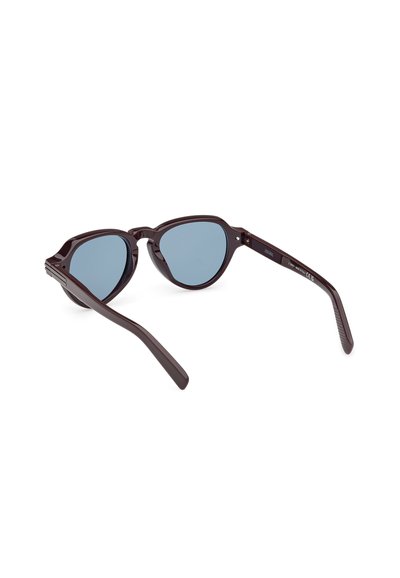 Sluneční brýle s tmavě hnědými plastovými rámy a modrými zrcadlovými skly. Mají tvar kočičích očí a jemně vroubkovaný design na spáncích.