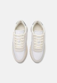 Witte sneakers met een bovenwerk van suede en glad leer, vetersluiting en een licht gevoerde zool met grijze accenten.