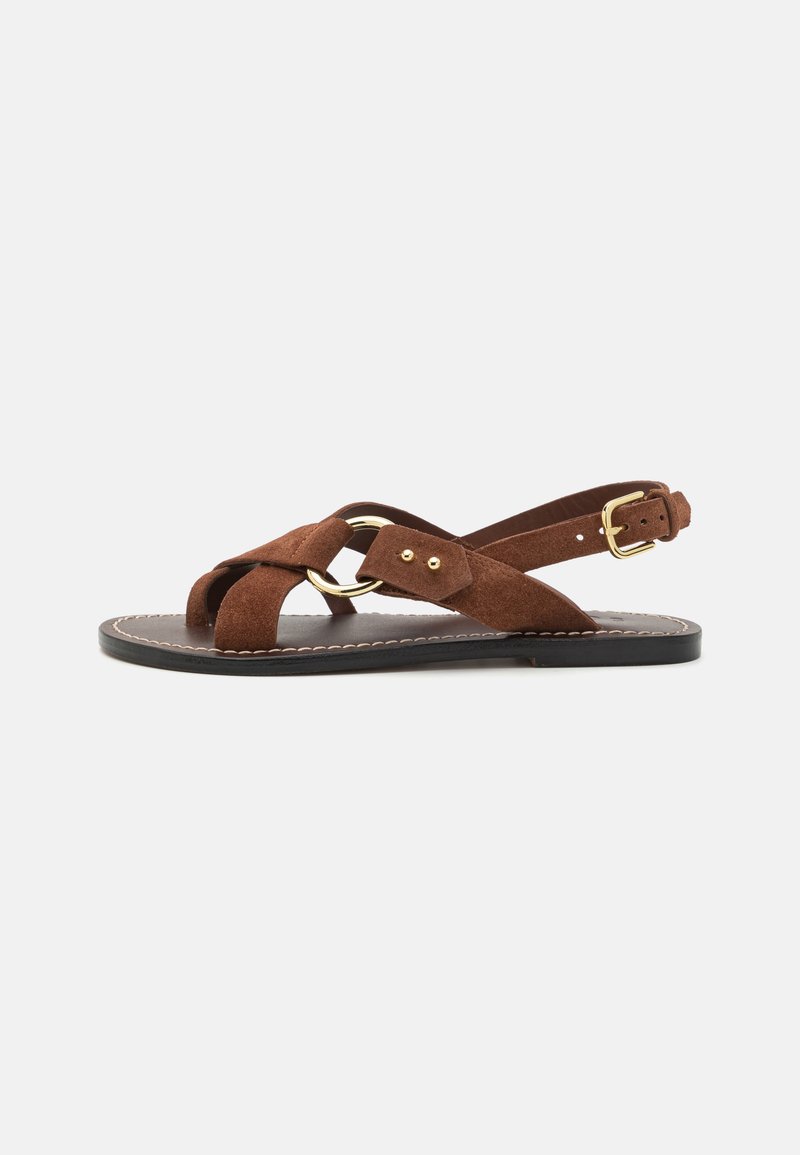 Brown suede sandal with crossed straps, gold hardware accent, adjustable ankle strap, flat sole, and minimal stitching details.