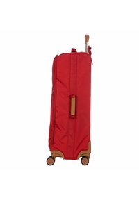 Valigia di stoffa rossa di forma rettangolare, con accenti in plastica marrone, chiusura a zip e quattro ruote per la mobilità. Manico estensibile dalla parte superiore.