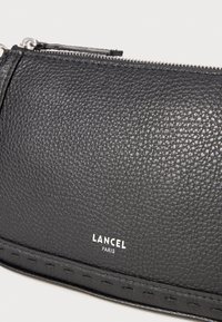 Must mustriga nahast kott, millel on tõmblukk ja ees valge "LANCEL PARIS" logo.