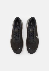 Scarpe sportive nere con tomaia in rete, accenti in suede testurizzato e suola con motivo. Presentano un logo riflettente e lacci neri.