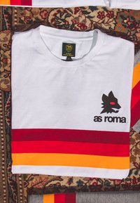 Witte katoenen t-shirt met een zwart wolf logo en de tekst "as roma", afgewerkt met rode, gele en oranje horizontale strepen.