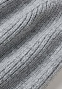 Tessuto di lana grigio a righe con una morbida texture, caratterizzato da strisce alternate in alto e piano per profondità e interesse visivo.