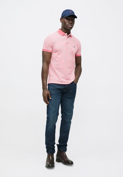 Īsroku krekls polo stilā ar sarkanām un baltām svītrām, ar kontrastējošu rozā apkakli, kombinēts ar tumši ziliem džinsiem un brūnām potīšu zābkām.