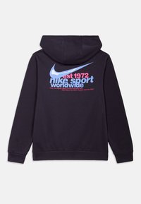 Crna dukserica s velikim plavim Nike logotipom, ružičastim i svijetloplavim natpisima te kengur džepom. Materijal izgleda mekano s glatkom teksturom.