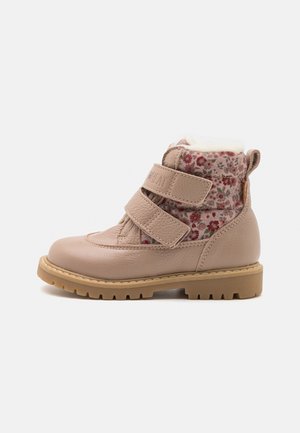 Botte rose en cuir avec une tige en tissu à motifs floraux, deux brides Velcro, une doublure en fausse fourrure et une semelle extérieure en caoutchouc beige robuste pour une meilleure adhérence.