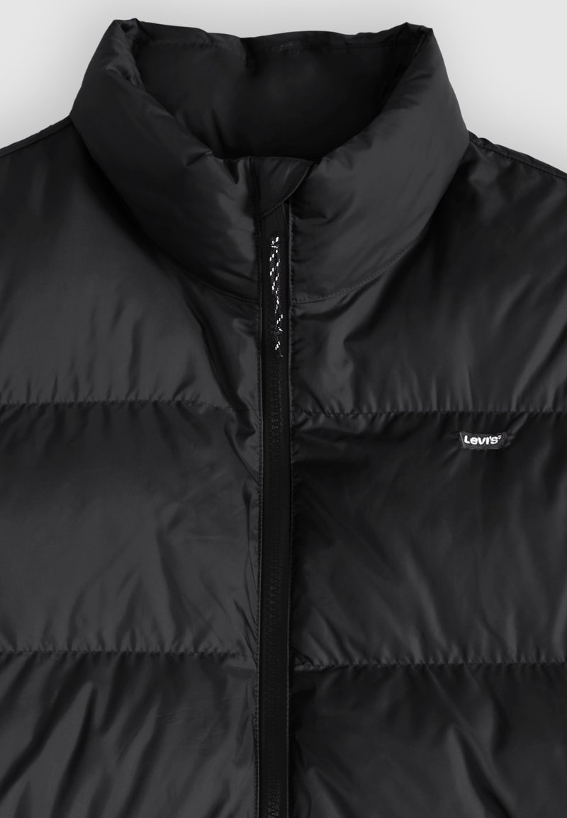 Chaleco acolchado negro de Levi's con cuello alto y cierre central con cremallera.