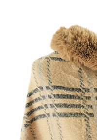 Poncho beige con una texture morbida e pelosa, caratterizzato da un motivo a quadri in tonalità di nero e argento, adornato con un colletto fluffy.