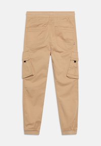 Beige cargo kalhoty s elastickým pasem, dvěma zadními kapsami a velkými klopovými kapsami na každé noze, zúžené nohavice s elastickými manžetami.