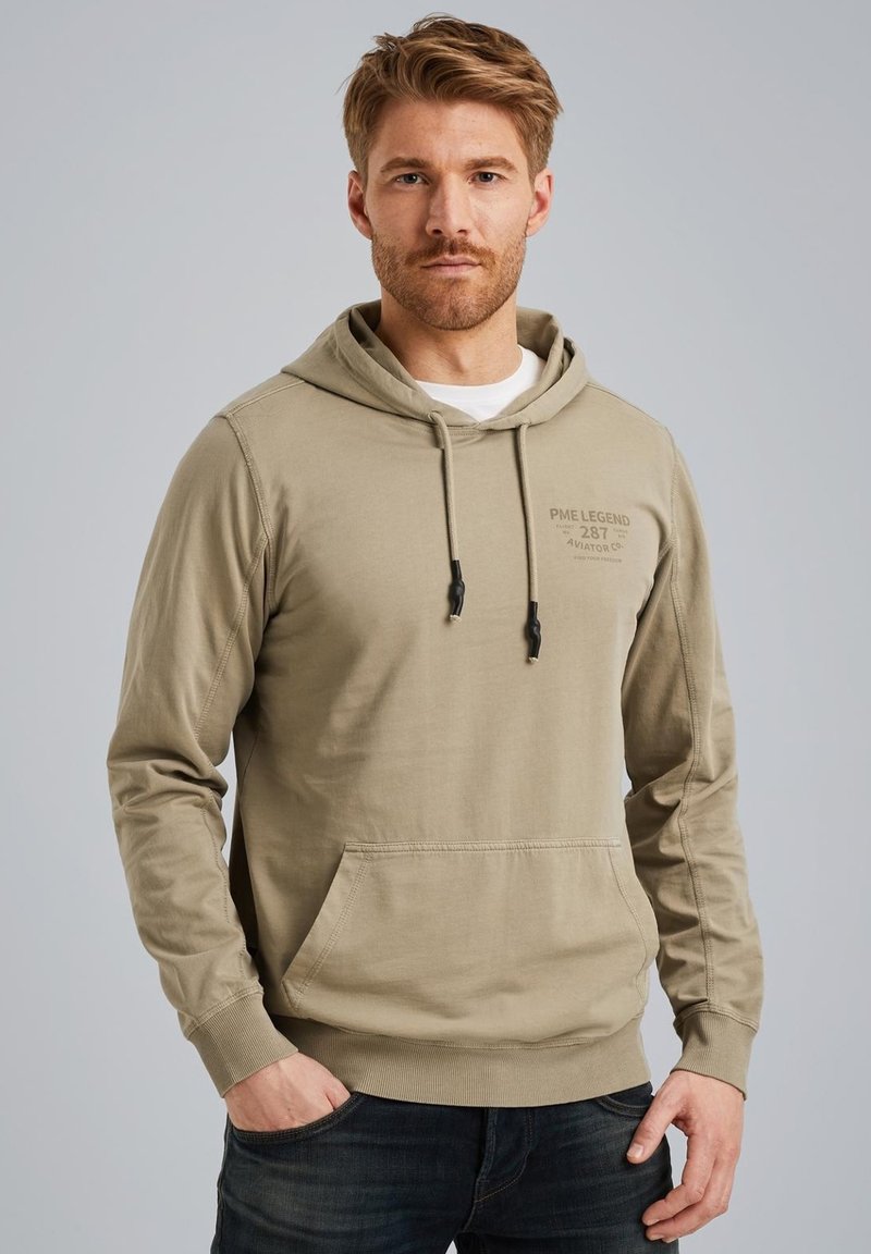 Sweat à capuche kaki avec une poche frontale, des cordons de serrage et un logo détaillé sur la poitrine ; fabriqué en tissu doux en mélange de coton.