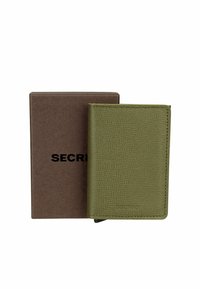 Portafoglio in pelle verde con una texture a grana leggera, posizionato accanto a una scatola di cartone marrone etichettata con "SEGRETO".
