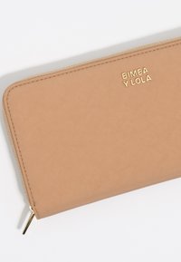 Cartera texturizada beige con un logo dorado "BIMBA Y LOLA". Presenta un cierre de cremallera y bordes lisos; forma rectangular compacta.
