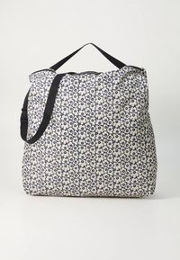 Torba za nošenje s cvjetnim uzorkom u teget plavoj i krem boji, s uzorkovanom vanjskom stranom, čvrstom ručkom i prostranim dizajnom prikladnim za razne namjene.