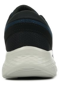 Scarpa sportiva nera con tomaia in tessuto testurizzato, suola bianca imbottita e strisce blu a contrasto. Presenta un tacco arrotondato e nessun marchio visibile.