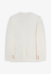 Chaqueta beige claro con un diseño ajustado, textura suave, una abertura en la parte trasera y cinco botones en cada puño.