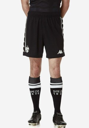 Pantaloncini sportivi neri con loghi bianchi, abbinati a calze nere al ginocchio con strisce bianche e scritte. Adatti per l'abbigliamento atletico.