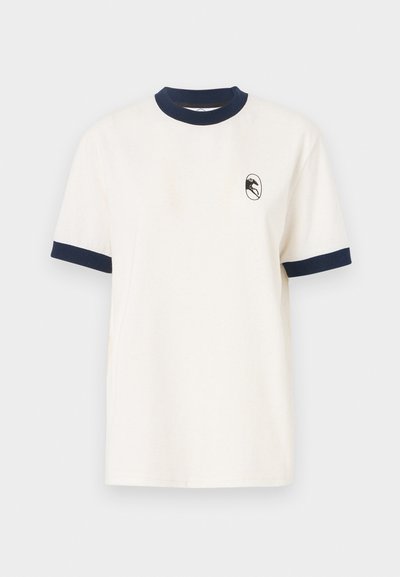 Cream-colored t-shirt with a navy ribbed collar and sleeve cuffs. Features a small logo emblem on the left chest area. Cotton fabric.