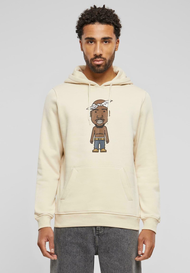 Un hoodie beige avec une poche avant et des cordons, présentant un personnage de dessin animé imprimé sur la poitrine, sur un fond uni.