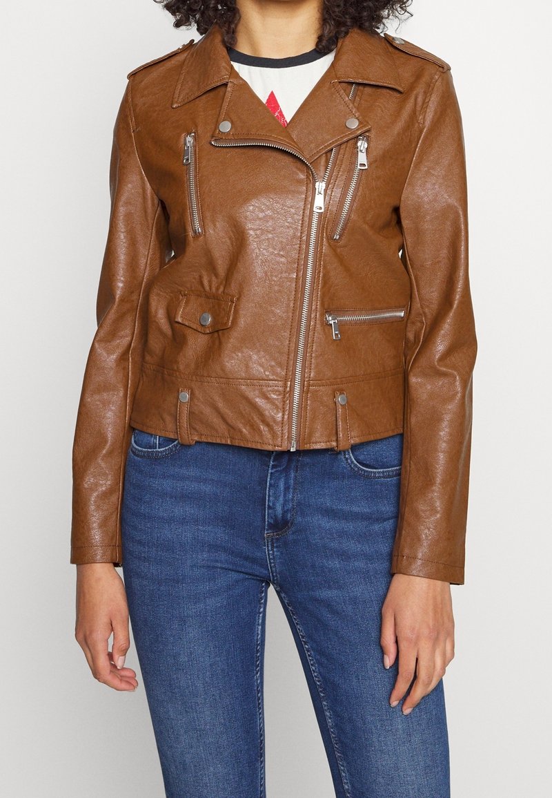 Veste de moto marron en cuir synthétique avec fermeture éclair asymétrique, deux poches poitrine et épaulettes. Coupe ajustée, texture lisse.