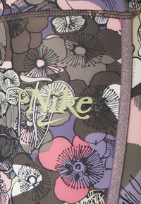 Nike leggings med et blomstermønster i brun, pink og lilla, med et fremtrædende Nike-logo. Tekstureret stof og glinsende kantdetaljer.