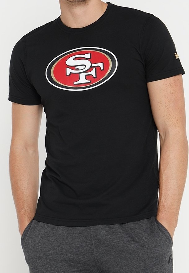 Camiseta negra de manga corta con un logotipo ovalado en rojo, blanco y dorado con "SF" en el centro. Fabricada con una tela suave y con un diseño ajustado.