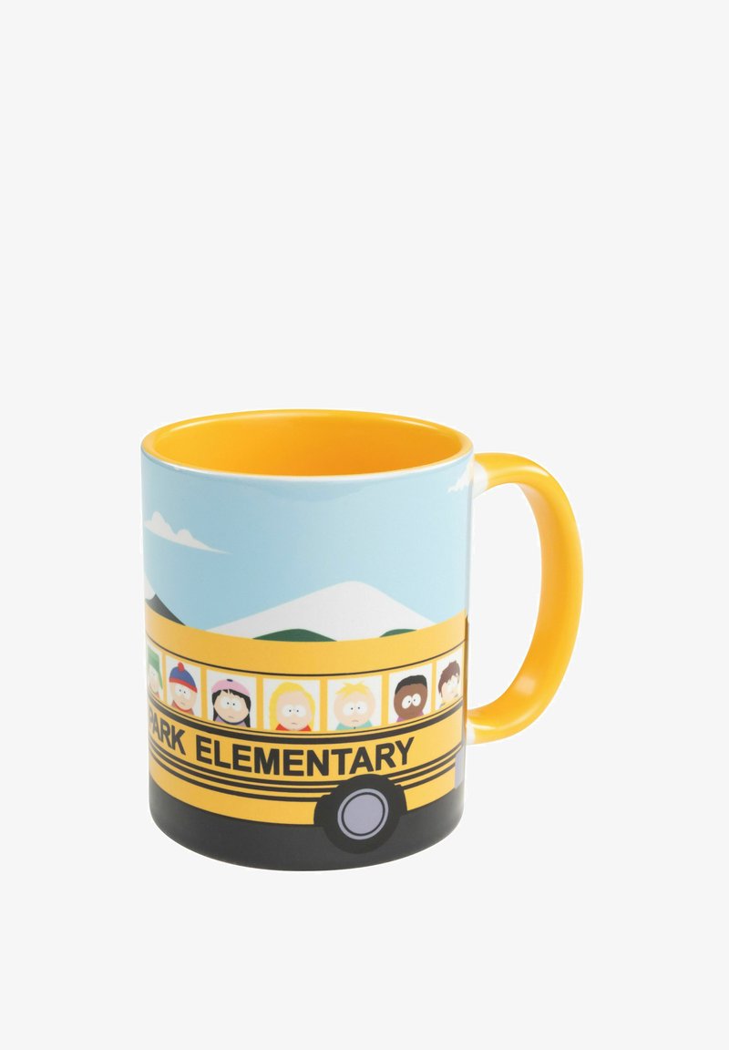 Tazza gialla con personaggi dei cartoni animati su un autobus scolastico giallo etichettato "Elementare" contro uno sfondo di cielo blu e montagne.