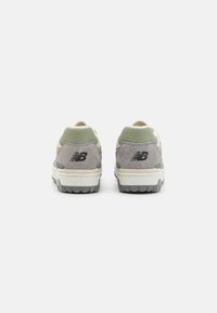 Gray suede and mesh sneakers with a beige accent, featuring a black logo on the heel and a rubber sole with a textured pattern.