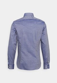 Vista posteriore di una camicia da uomo a maniche lunghe, con bottoni, di colore blu chiaro e colletto classico su uno sfondo bianco semplice.