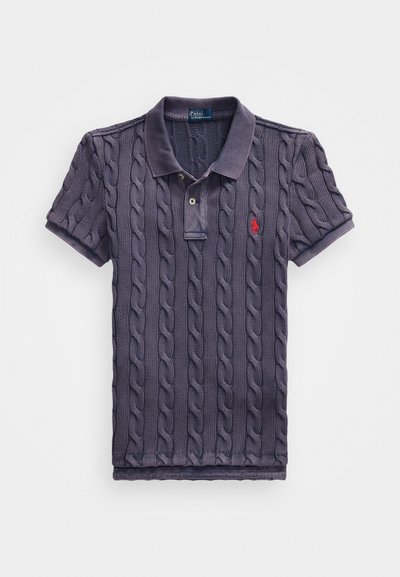 Polo shirt bleu marine avec texture en maille torsadée, replié avec un col et deux boutons. Présente un petit logo rouge sur la poitrine gauche.