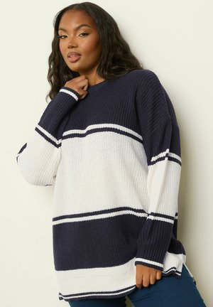 Strickpullover in Marineblau und Weiß mit horizontalen Streifen, langen Ärmeln und Rundhalsausschnitt. Rippstruktur mit seitlichen Schlitzen am Saum.