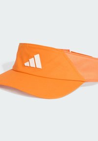 Pomarańczowy sportowy daszek wykonany z lekkiego materiału z szerokim rondem. Posiada białe logo z trzema paskami na przedniej części oraz akcenty z siateczki.