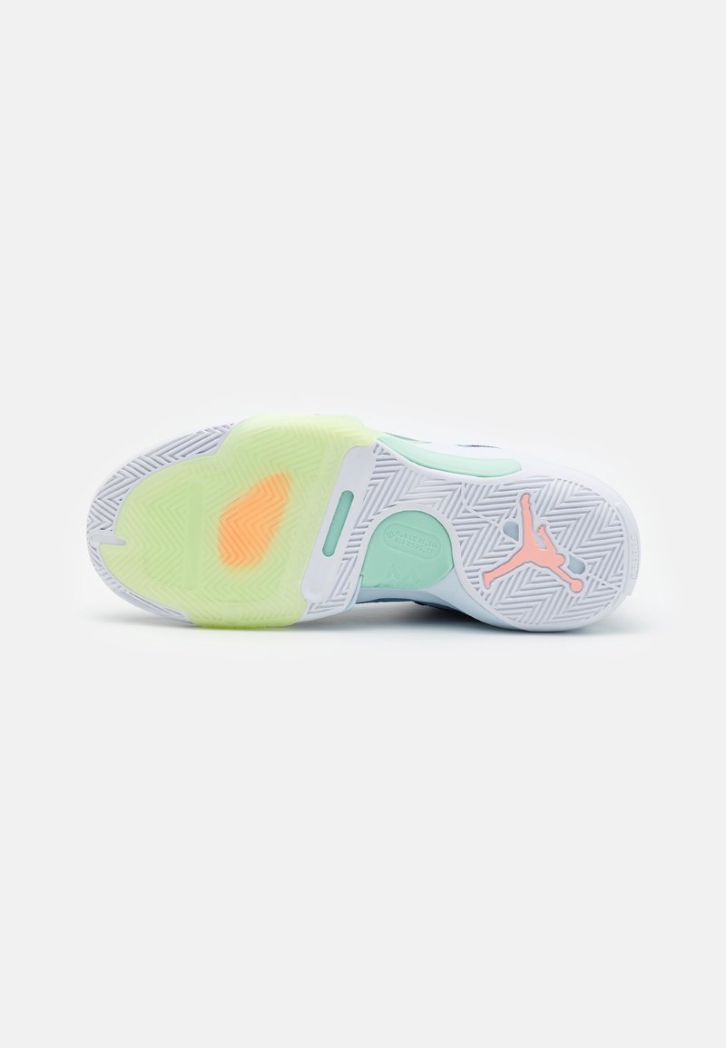 Semelle d'une basket Air Jordan blanche et vert menthe avec logo Jumpman orange et accents translucides jaunes et orange.