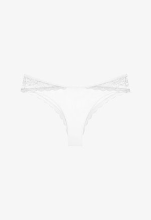 Λευκά εσώρουχα μπικίνι από δαντέλα με κυματιστά περιθώρια και διάφανη δαντέλα με λουλουδάτο σχέδιο στη ζώνη μέσης.