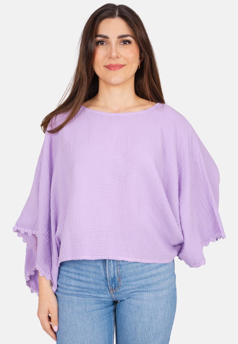 Lavendel, leichter Pullover mit strukturierter Oberfläche, weiten Ärmeln und Spitze am Saum. Kombiniert mit blauen Jeans.